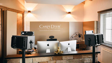 Carpe Diem Studio 3 Rückwand mit A115 Breitbandabsorber mit Logo, links oben ist die konstruktive Bassfalle im Anschnitt zu erkennen.
